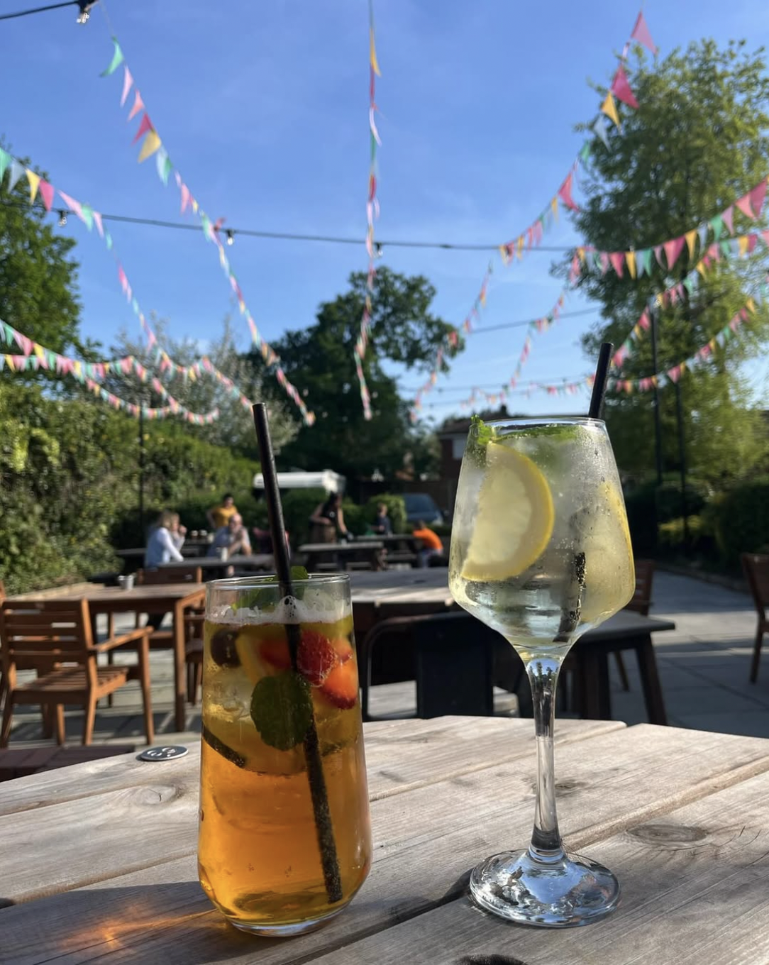 Pimm's and a gin and tonic on a table in the beer garden under bunting